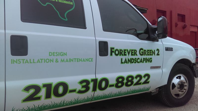 Landscaping company truck with green vinyl lettering and logo