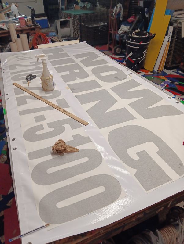 Large format banner being printed and trimmed in the shop