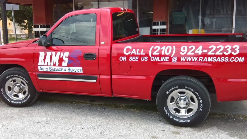 Red pickup truck with custom door lettering and phone number