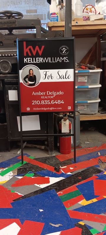 Real estate yard signs with agent rider panels on a display stand