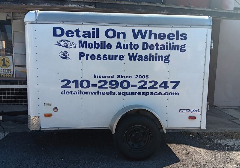 Mobile auto detailing trailer with custom vehicle lettering and phone number